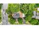 Aerial view of home with mature trees, black roof, and ample parking, surrounded by lush green landscape at 347 W Trade St, Burlington, NC 27217