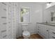 Cozy bathroom with a granite-topped vanity, a toilet, and a shower with a neutral curtain at 347 W Trade St, Burlington, NC 27217