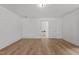Bright bedroom with wood-look floors, white walls, and open doorways creating an airy, connected living space at 347 W Trade St, Burlington, NC 27217