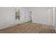 Bright bedroom with light wood floors, white walls, and a window at 347 W Trade St, Burlington, NC 27217