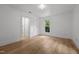 Bright bedroom featuring natural light, white trim and doors, and neutral wood-look flooring for a calm retreat at 347 W Trade St, Burlington, NC 27217