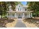 Charming white two-story home with a welcoming front porch and well-maintained landscaping at 347 W Trade St, Burlington, NC 27217