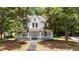 Charming two-story home with a inviting front porch and a classic design, surrounded by mature trees at 347 W Trade St, Burlington, NC 27217