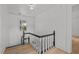Bright staircase featuring wood floors, white risers, and a black handrail, leading to the upper level at 347 W Trade St, Burlington, NC 27217
