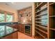 Contemporary bar area with granite countertop, mini fridge, stone accent wall, and beautiful cabinetry at 3707 Stonegate Dr, Chapel Hill, NC 27516
