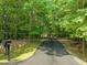 A long, private driveway leads through the forest to the home with mature shade trees at 3707 Stonegate Dr, Chapel Hill, NC 27516