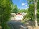 A home with a two car garage, set amongst mature trees with a well maintained driveway and landscaping at 3707 Stonegate Dr, Chapel Hill, NC 27516