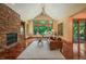 Bright living room features a stone fireplace, hardwood floors, and large windows with views of the surrounding greenery at 3707 Stonegate Dr, Chapel Hill, NC 27516