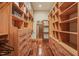 Spacious walk-in closet featuring custom built-in shelving and drawers and hardwood floor at 3707 Stonegate Dr, Chapel Hill, NC 27516