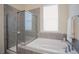 Bathroom features a separate glass shower and a soaking tub with gray tile surround at 41 Highveld Ave, Chapel Hill, NC 27516