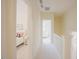 Bright hallway with white trim leads to bedrooms; bedroom has white bed with pink accents at 41 Highveld Ave, Chapel Hill, NC 27516