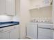 Functional laundry room with white cabinetry, countertop, and modern washer and dryer units at 41 Highveld Ave, Chapel Hill, NC 27516