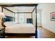 Elegantly appointed main bedroom featuring hardwood floors, natural light, and a stylish four-poster bed at 41 Highveld Ave, Chapel Hill, NC 27516