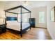 Main bedroom with a four-poster bed, natural light, hardwood floors, and ample space for relaxation at 41 Highveld Ave, Chapel Hill, NC 27516