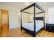 Bright main bedroom with ensuite bathroom, featuring hardwood floors, a four-poster bed, and ample natural light at 41 Highveld Ave, Chapel Hill, NC 27516
