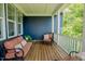 Covered porch with wooden flooring and blue siding featuring comfortable seating with patterned cushions at 41 Highveld Ave, Chapel Hill, NC 27516