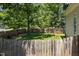 Fenced backyard offering a private and serene outdoor space with mature trees and well-maintained lawn at 413 Great Smokey Mountain Dr, Mebane, NC 27302