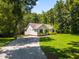 Beautiful single-story home featuring a well-maintained lawn and gravel driveway surrounded by mature trees at 4217 Us-70, Durham, NC 27705