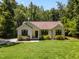 Charming single-story home with a white exterior, well-manicured lawn and mature trees at 4217 Us-70, Durham, NC 27705