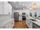 Modern kitchen featuring white cabinets, stainless steel appliances and stylish pendant lighting at 4217 Us-70, Durham, NC 27705
