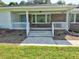 Charming brick home featuring a covered front porch with a welcoming blue door and freshly landscaped yard at 4414 Nc Hwy 87 N, Pittsboro, NC 27312
