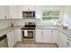 Modern kitchen with white cabinets, granite countertops, and stainless steel appliances at 4414 Nc Hwy 87 N, Pittsboro, NC 27312