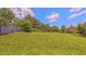 Backyard view of large grassy lawn, blue skies and lush green foliage at 4928 Silverdene St, Raleigh, NC 27616