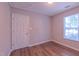 A cozy bedroom with wood-look flooring and natural light from a window at 4928 Silverdene St, Raleigh, NC 27616
