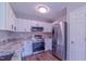 Updated kitchen featuring stainless steel appliances, white cabinets, and granite countertops at 4928 Silverdene St, Raleigh, NC 27616
