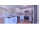 Modern kitchen with stainless appliances, white cabinets, granite counters and wood-look floors at 4928 Silverdene St, Raleigh, NC 27616