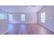 Spacious living room featuring wood-look floors, pendant lighting, and ample natural light at 4928 Silverdene St, Raleigh, NC 27616