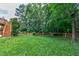 A well-maintained backyard with a lush lawn, mature trees, and wooden perimeter fence at 500 Walcott Way, Cary, NC 27519