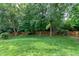 Backyard featuring mature trees, grass, and a wooden perimeter fence at 500 Walcott Way, Cary, NC 27519