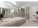 Luxurious bathroom with a soaking tub, glass-enclosed shower, and tile flooring at 500 Walcott Way, Cary, NC 27519