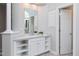 Well-lit bathroom features a large mirror, white cabinets, and a separate door for privacy at 500 Walcott Way, Cary, NC 27519