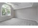Neutral bedroom with a ceiling fan, a large window, and plush carpet at 500 Walcott Way, Cary, NC 27519
