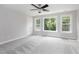 Spacious bedroom with a ceiling fan, two large windows, and a neutral color palette at 500 Walcott Way, Cary, NC 27519