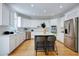 Modern kitchen with stainless steel appliances, white cabinets, and a large island at 500 Walcott Way, Cary, NC 27519