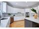 Contemporary kitchen featuring white cabinets, quartz countertops, and stainless appliances at 500 Walcott Way, Cary, NC 27519