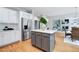 Open kitchen features a central island, stainless steel refrigerator, and flows into the living room at 500 Walcott Way, Cary, NC 27519