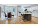 Bright kitchen with island and breakfast bar adjacent to dining area with large windows at 500 Walcott Way, Cary, NC 27519