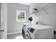 Functional laundry room featuring a large window, washer, dryer, and shelving at 500 Walcott Way, Cary, NC 27519