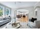 Open living space with hardwood floors, a large window, and connection to the kitchen at 500 Walcott Way, Cary, NC 27519