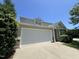 A front facing view of the two-car garage, driveway, and landscaped front yard at 5819 Finestra Way, Raleigh, NC 27610