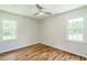 Bedroom featuring hardwood floors, two windows, ceiling fan and neutral paint at 605 Sagefield Way, Henderson, NC 27537