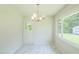 Bright dining area with marble floors, modern light fixture, and large windows overlooking the yard at 605 Sagefield Way, Henderson, NC 27537