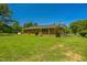 Brick ranch-style home surrounded by a lush green lawn and mature trees at 605 Sagefield Way, Henderson, NC 27537