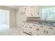 Bright kitchen features white cabinetry, granite countertops and a stainless steel sink at 605 Sagefield Way, Henderson, NC 27537