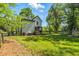Expansive backyard with lush green grass, covered patio, storage shed, and wooden fence at 605 W Holt St, Mebane, NC 27302