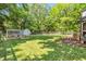 Backyard showcasing a shed, chicken coop, privacy fence, and verdant lawn at 605 W Holt St, Mebane, NC 27302